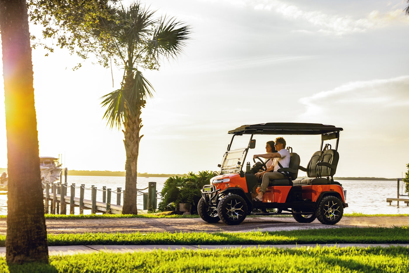 A man and a woman riding a golf cart