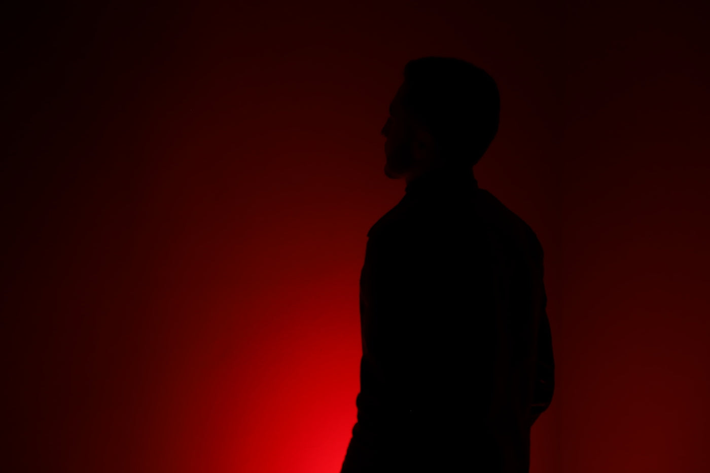 silhouette of person standing in front of red wall